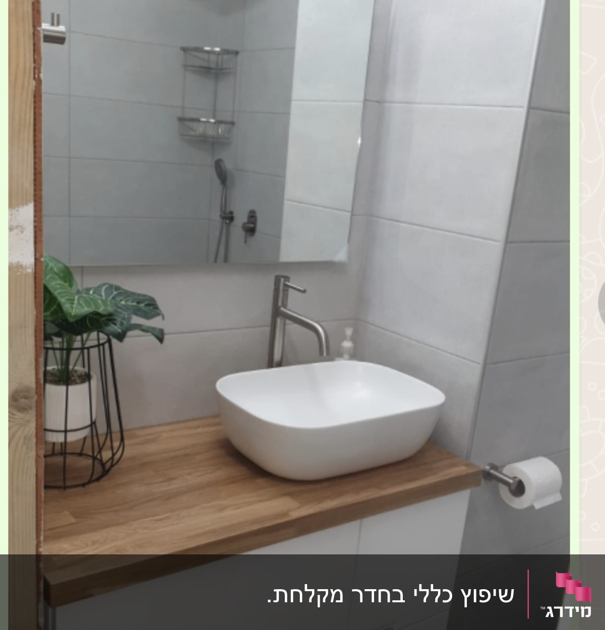 כיור לבן על משטח עץ בחדר אמבטיה משופץ